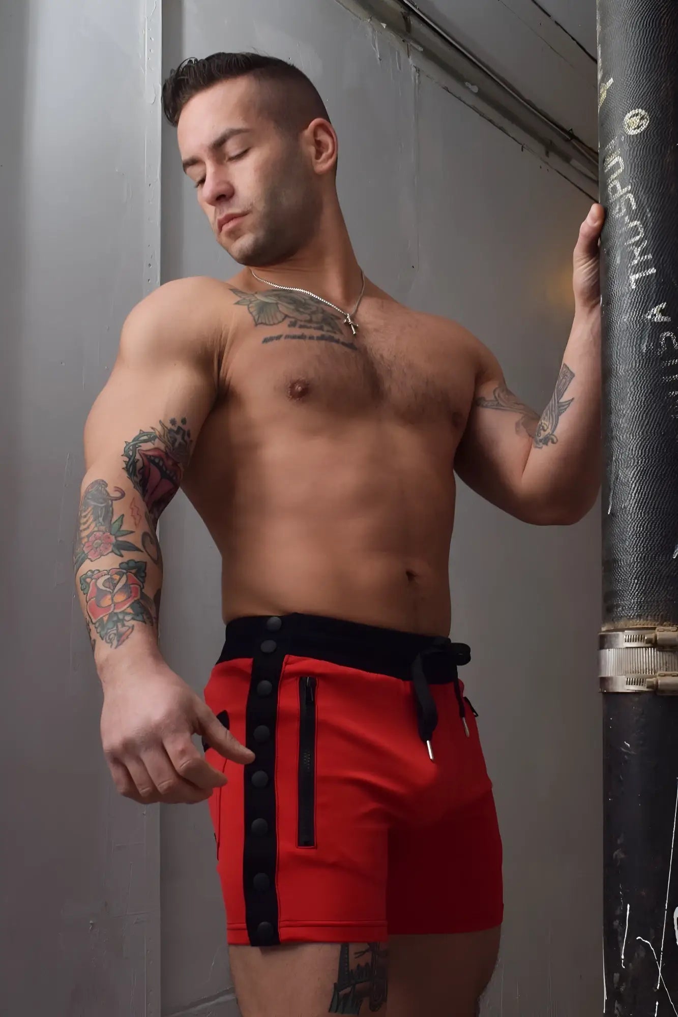 Red backpack shorts featuring black side panels with zipper details designed for athletic use
