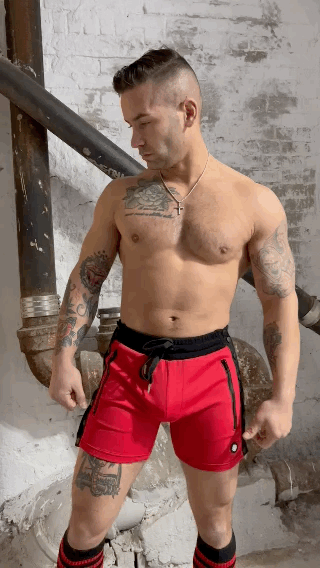 Red backpack shorts with black side panels and matching drawstring waistband designed for athletic use