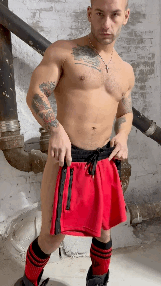 Red backpack shorts with black side zippers and matching drawstring waistband designed for athletic use