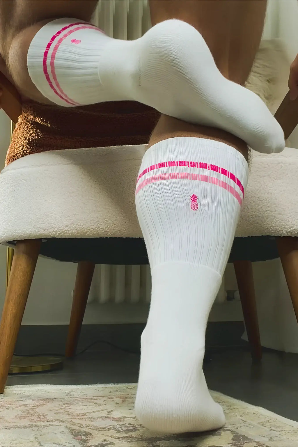 White banded high socks with pink strawberry stripes and a small pineapple logo for athletic use