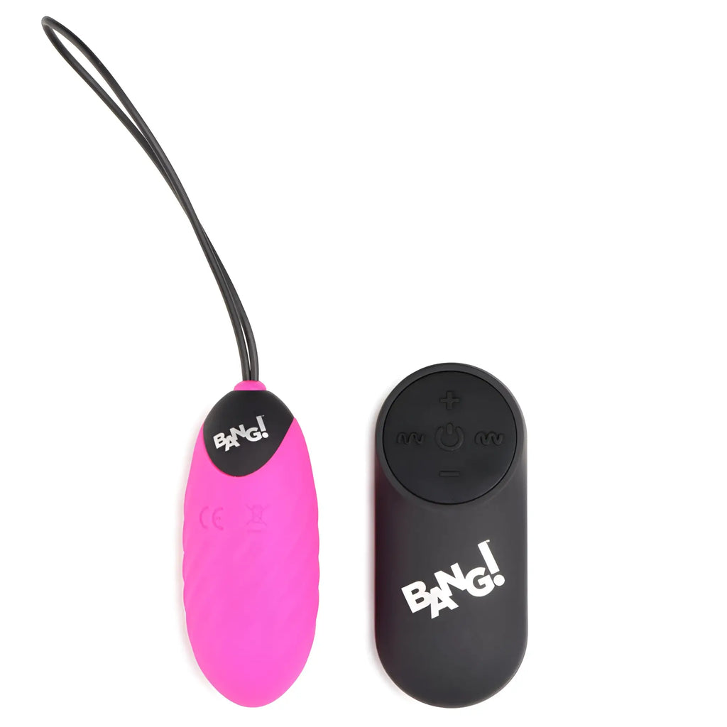 Bang 28X pink nubbed vibrating egg with a black cord and matching black remote control on a white background.