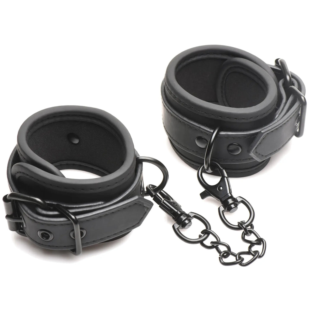 Black leather wrist cuffs with chain and clasp from BANG bondage kit for secure restraint use