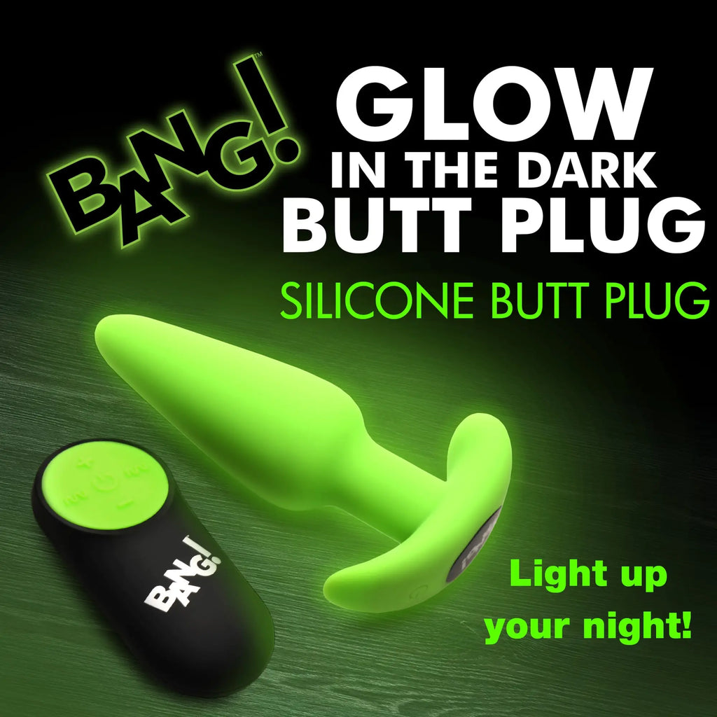 Bang Glow-in-the-Dark silicone butt plug with a black remote, shown against a green-lit background.