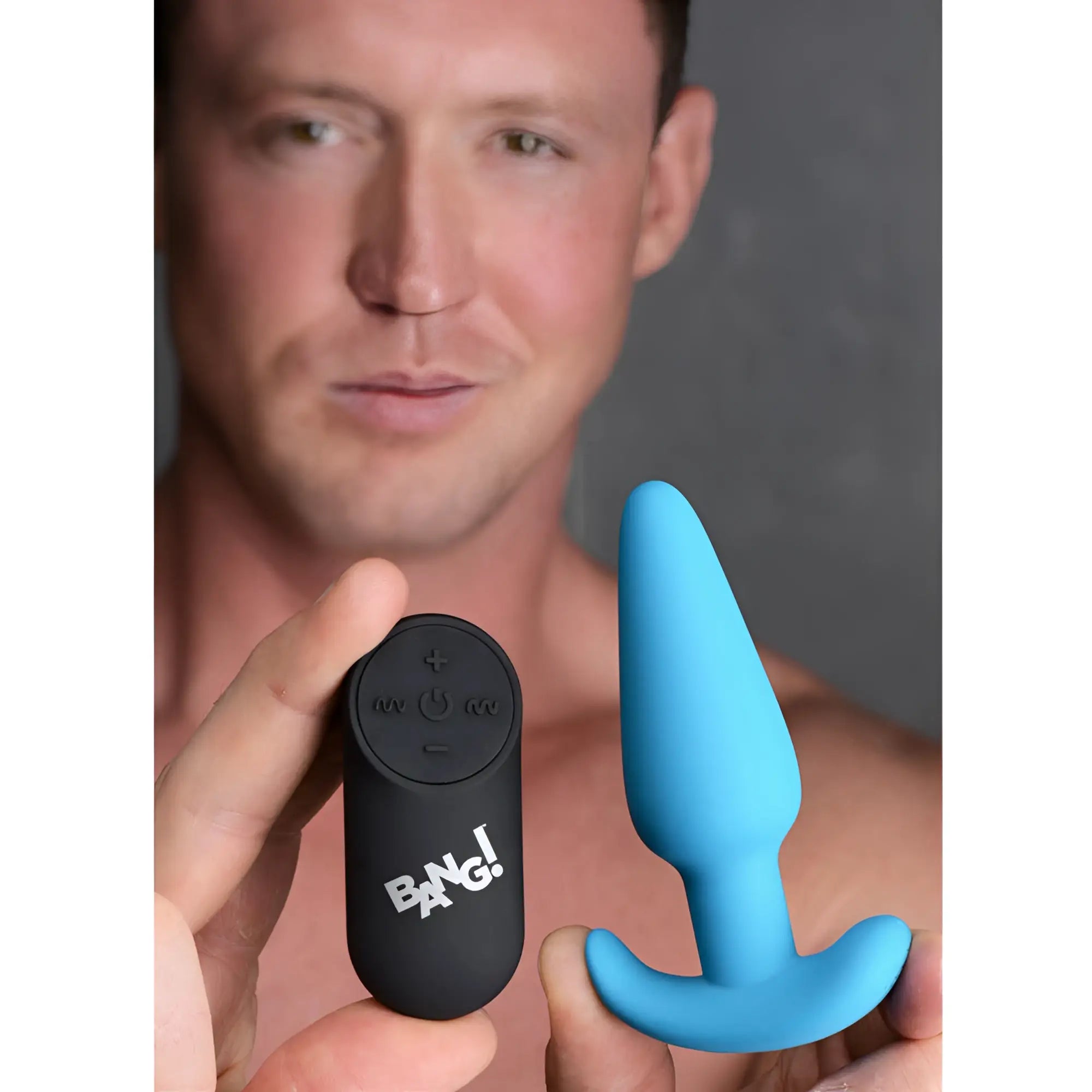 Bang Remote Control 21X Vibrating Silicone Butt Plug: A light blue silicone plug next to a black remote control.