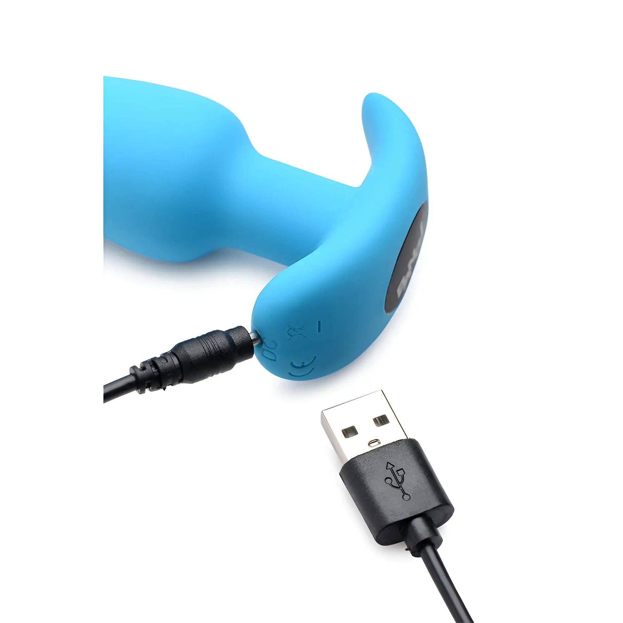 Bright blue Bang 21X vibrating silicone butt plug being charged with a black USB cable against a white background.