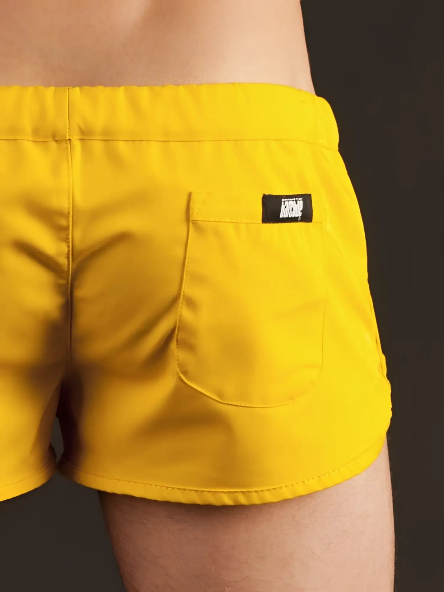 Bright yellow Barcode Berlin gym shorts xl shown from the back with a black brand patch on the pocket