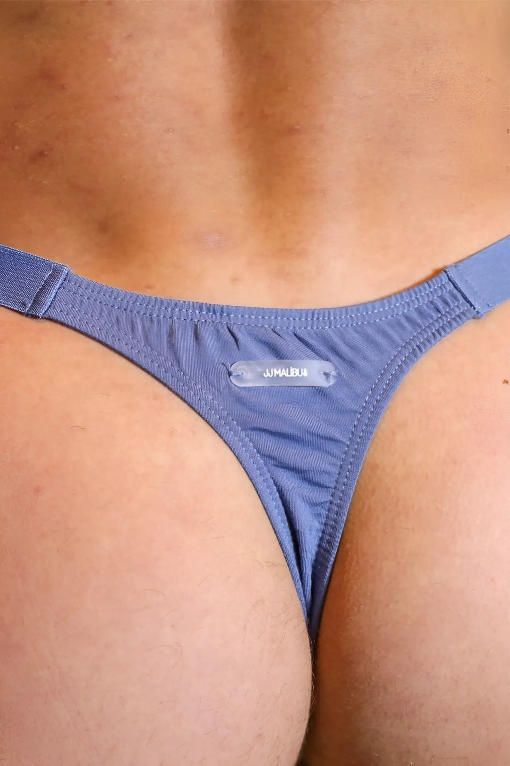 Blue denim modal thong with a clear plastic jimalbua brand tag for barely there comfort and style