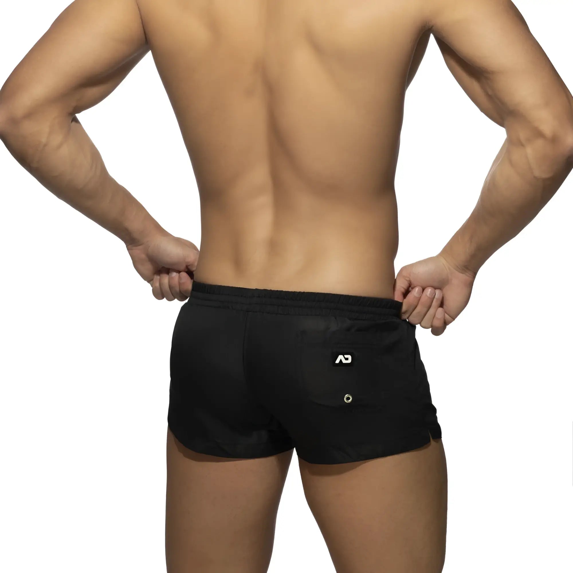 Back side of black basic mini shorts with white logo on the back pocket made from lightweight fabric