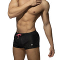 Basic mini short black swim trunks with pink drawstring and white logo on lower left leg for casual beachwear