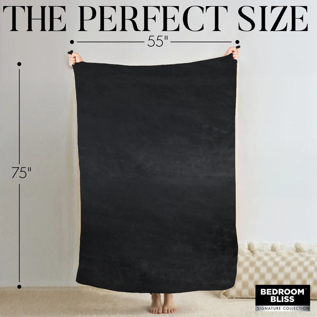 Hands holding a solid black Bedroom Bliss waterproof throw blanket, labeled with 55" by 75" dimensions.