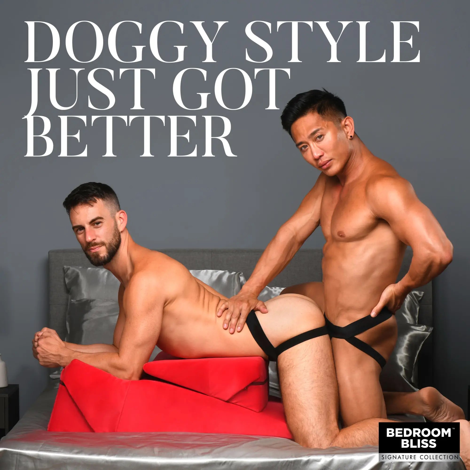 Two men using a red Bedroom Bliss Love Cushion set on a bed. The set features ergonomic, wedge-shaped red cushions.