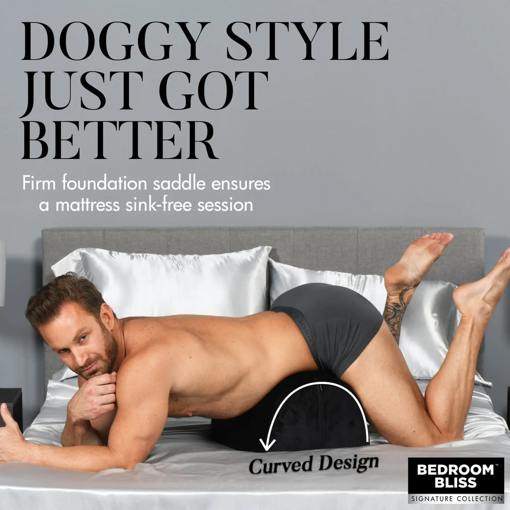 Bedroom Bliss Love Toy Cushion: A black, curved, firm foam support cushion shown in use on a bed.
