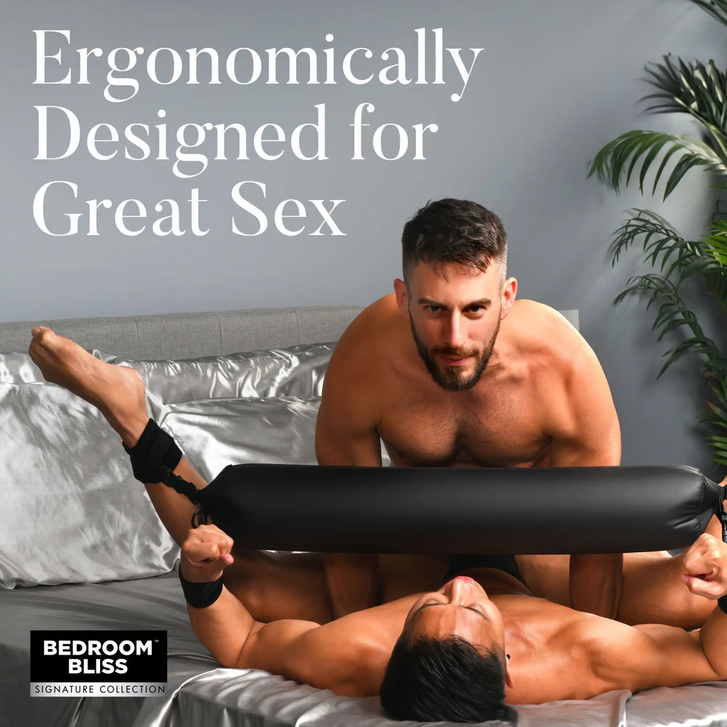 Bedroom Bliss Padded Spreader Bar: a black, cushioned bar with wrist and ankle restraints being used on a bed.