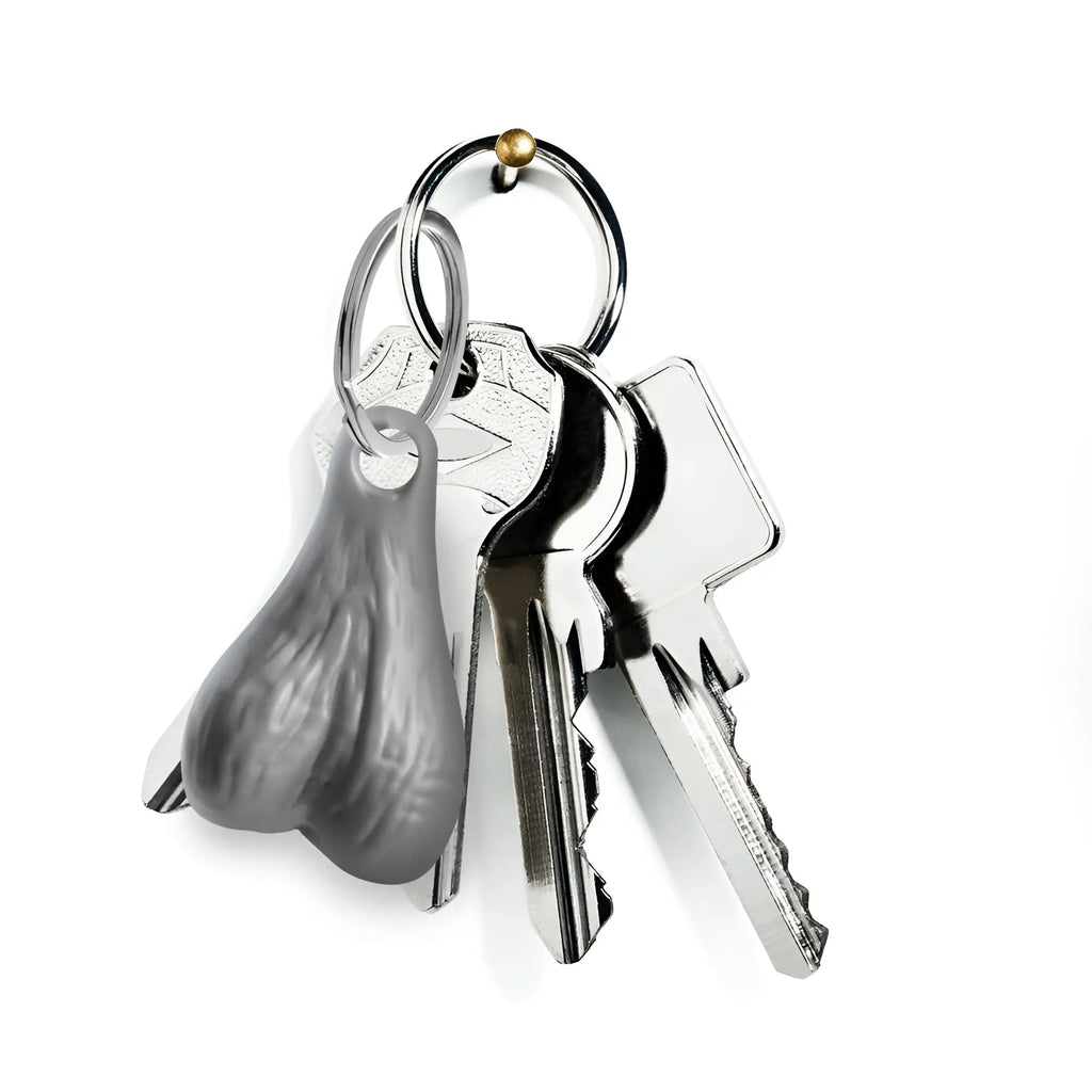 Big Ballers keychain: A grey, textured, anatomical-style pendant hanging on a metal keyring with two silver keys.