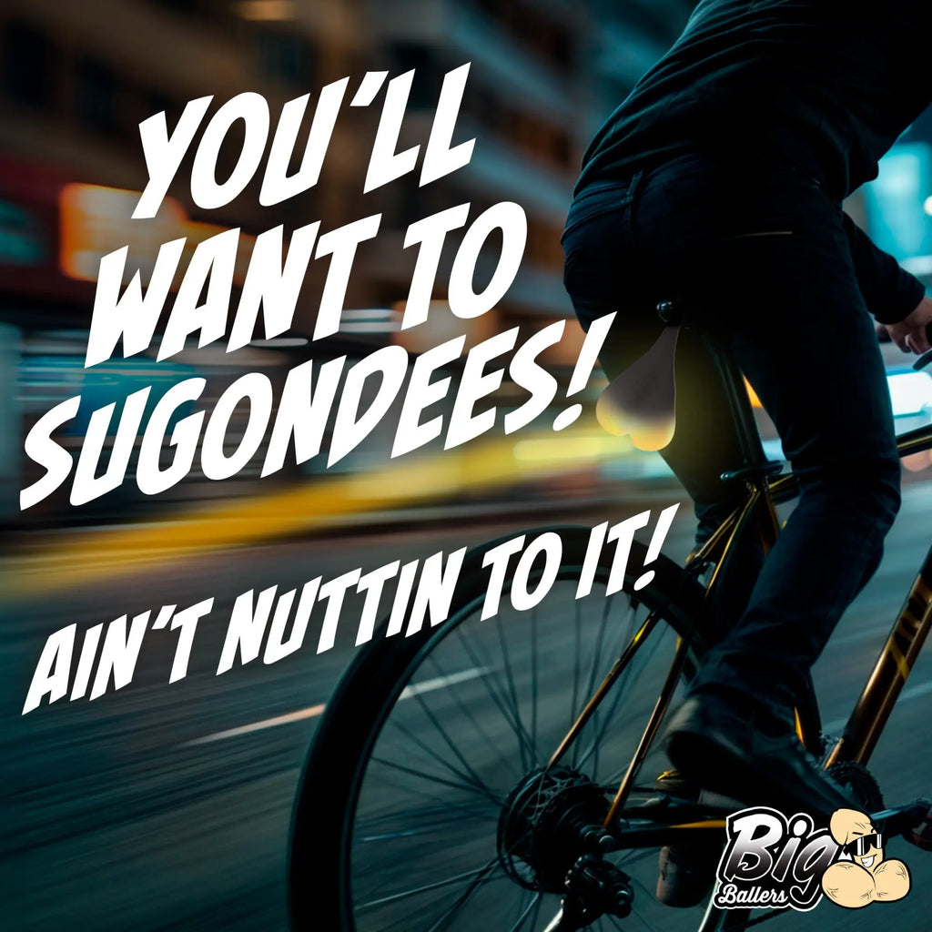 Big Ballers Teeny Weeny Truck Nuts: A glowing, scrotum-shaped bike tail light attached under a bicycle seat at night.