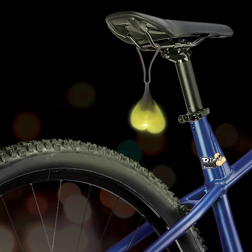 Big Ballers Teeny Weeny Truck Nuts: A glowing, heart-shaped silicone light hanging from a bicycle seat.