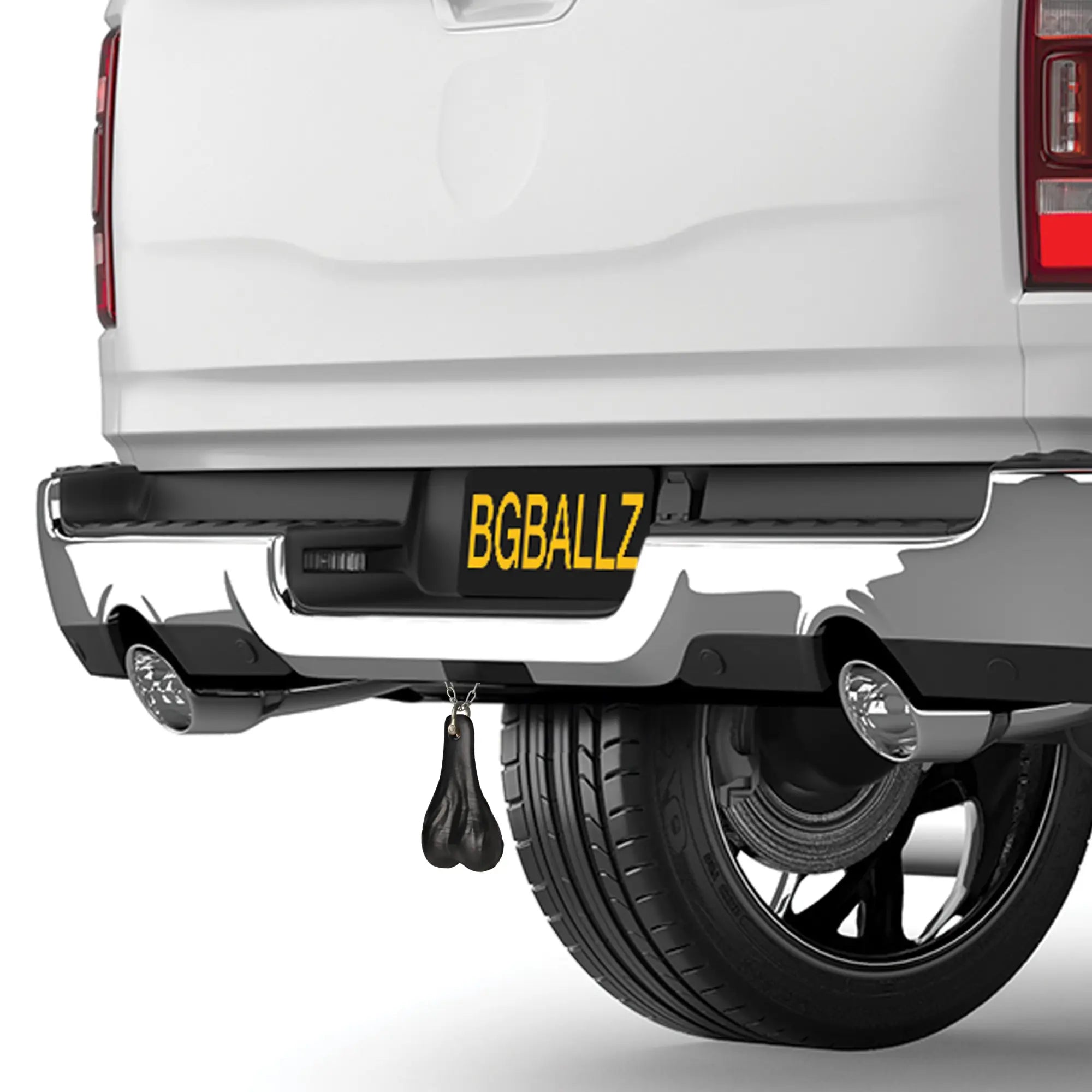 Big Ballers Truck Nuts in matte black hanging from the rear bumper of a white pickup truck.