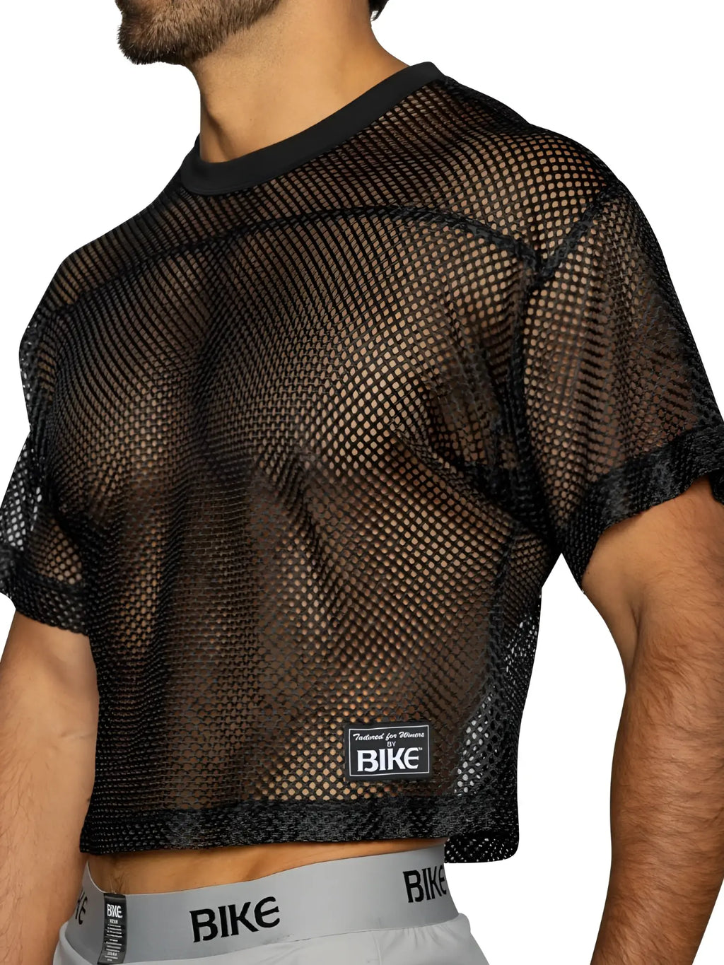 Black mesh crop top with solid ribbed neckline and cuffs featuring bike brand label in bold color black