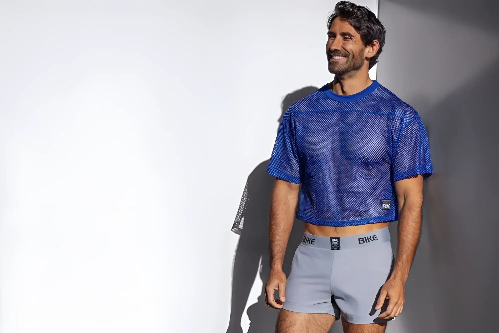 Blue mesh crop top with subtle texture and small black logo on lower left side in bike athletic royal practice jersey