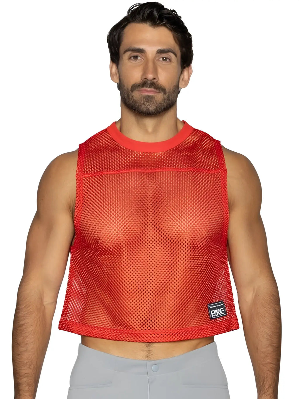 Red mesh crop top with ribbed neckline and hem featuring small black bike brand patch on lower right side