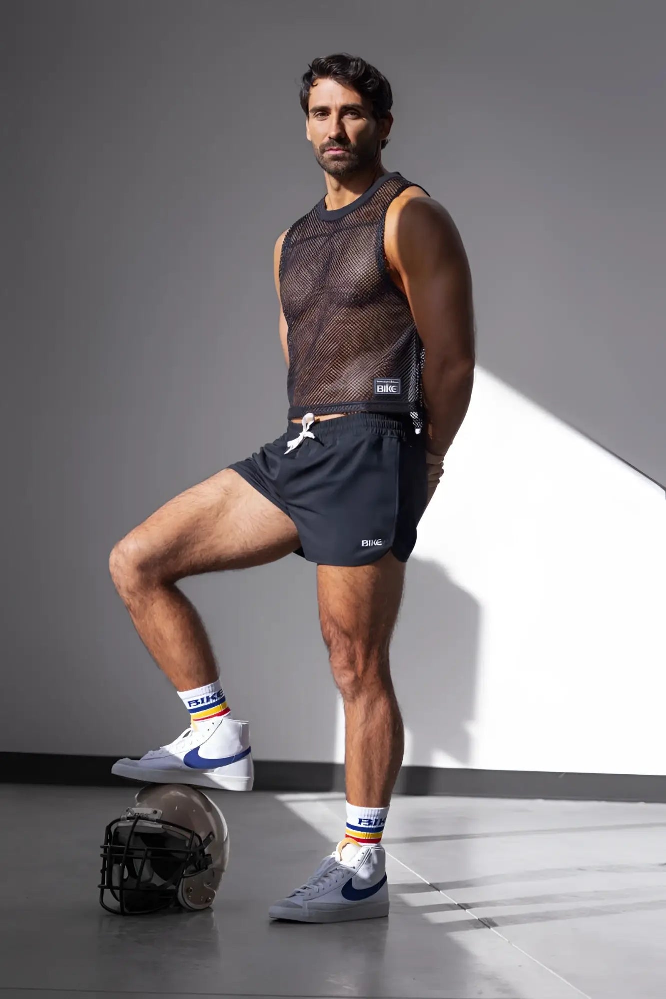Black mesh sleeveless top with a small white logo on the lower right side paired with bike athletic bam200 black track shorts