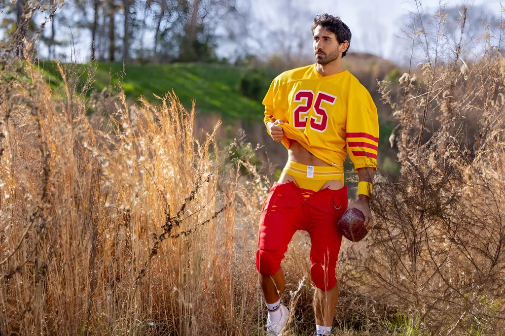 Yellow football jersey with red number 25 and stripes paired with red pants from BIKE Athletic BAS306 jockstrap collection