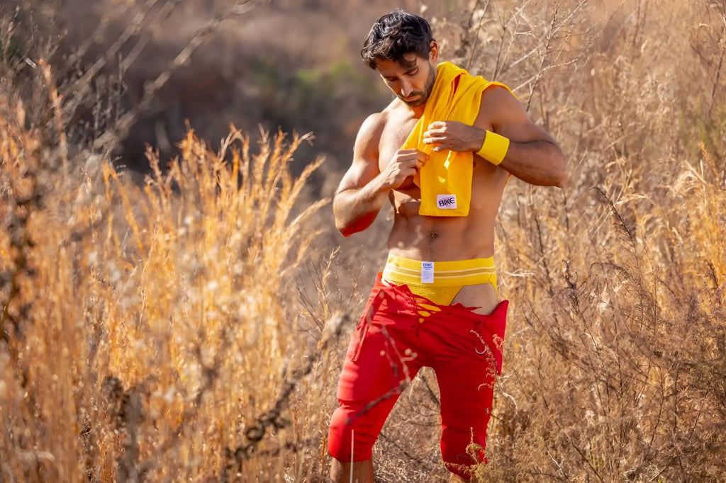 Man wearing a yellow bike athletic bas306 original number 10 yellow jockstrap with a small white logo outdoors