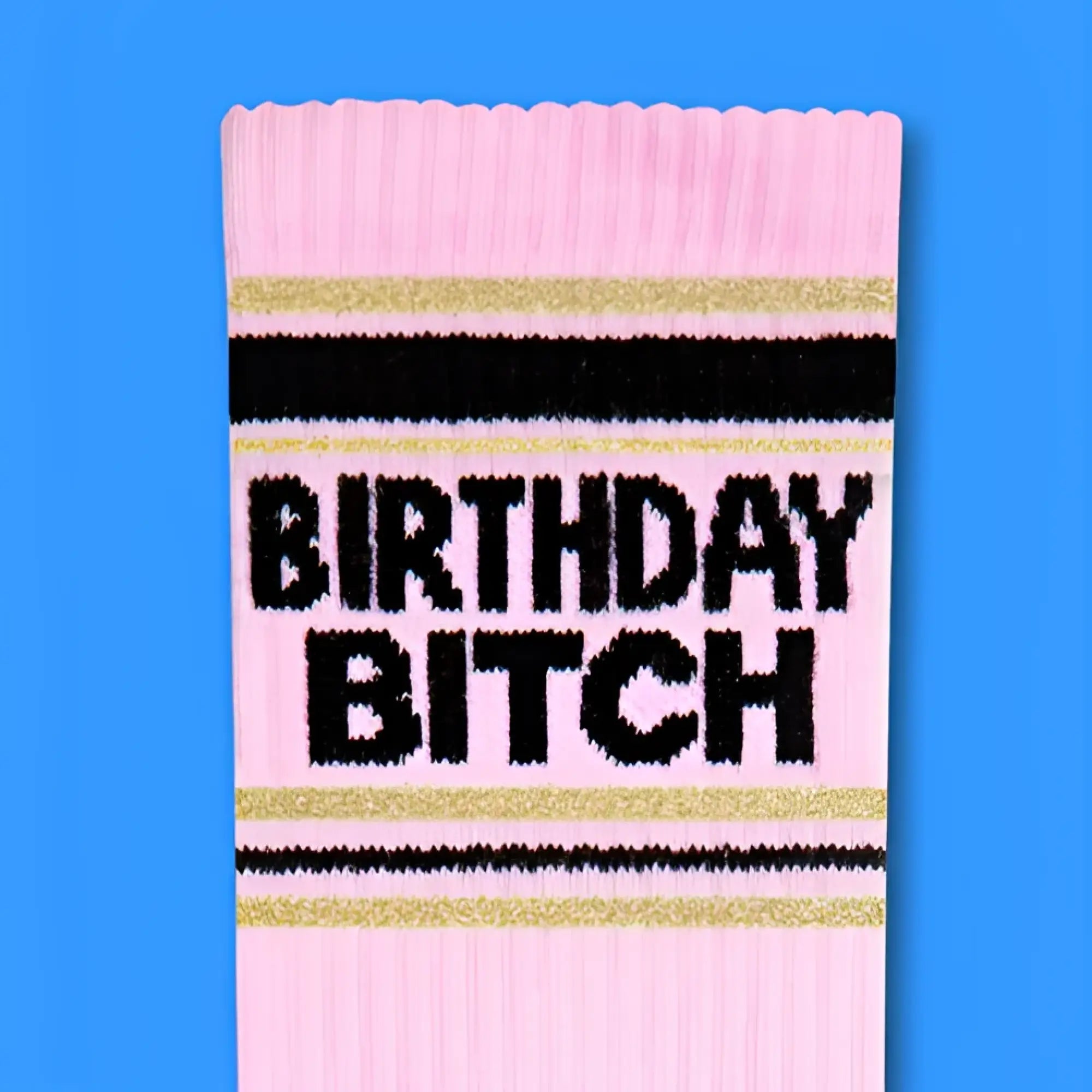 Pink ribbed birthday bitch crew socks with black and gold stripes and bold glittery black text design