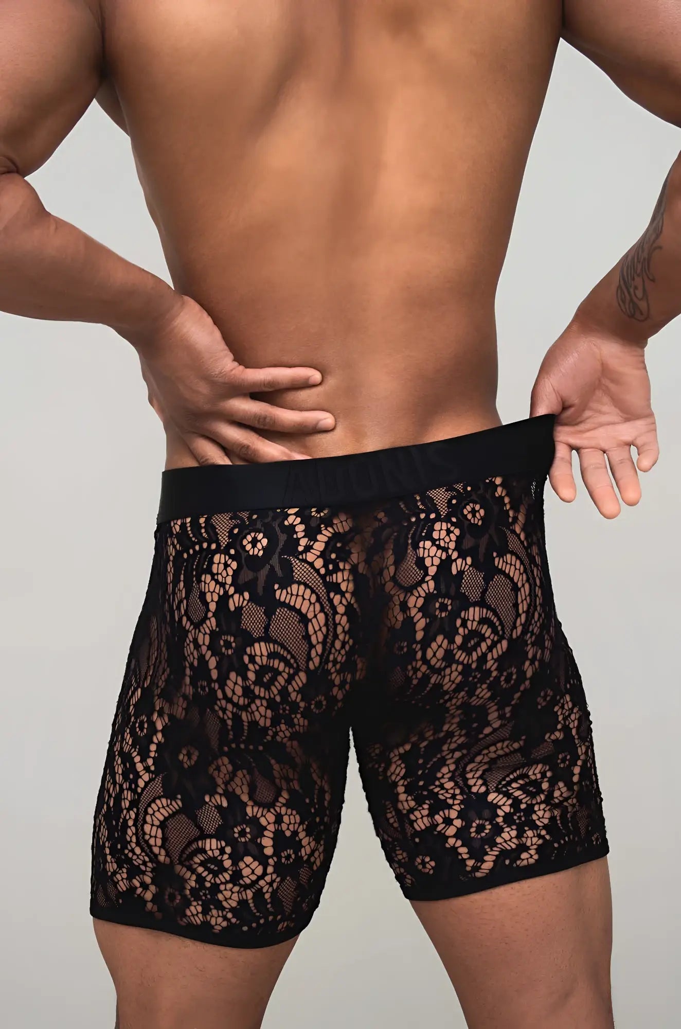 Black sheer lace boxer brief with intricate floral pattern and solid black elastic waistband