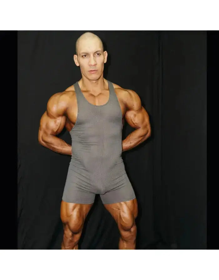 Grey mesh wrestler bodysuit by Arroyman featuring a sleeveless design and form-fitting cut modeled by a muscular individual.