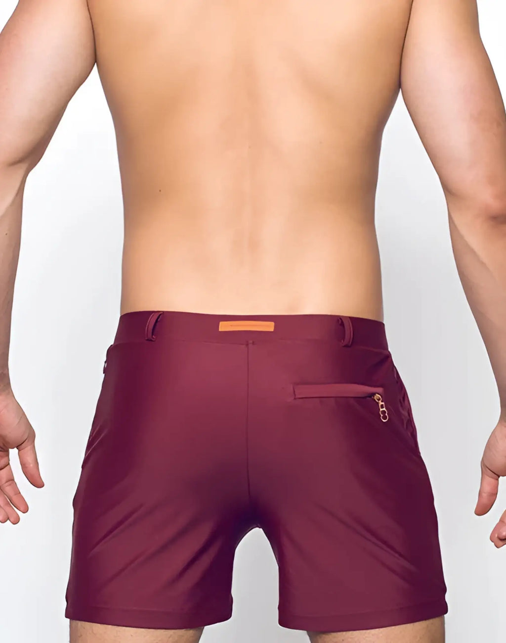 Maroon bondi short swim trunks with subtle textured finish and orange rectangular brand tag at the waistband