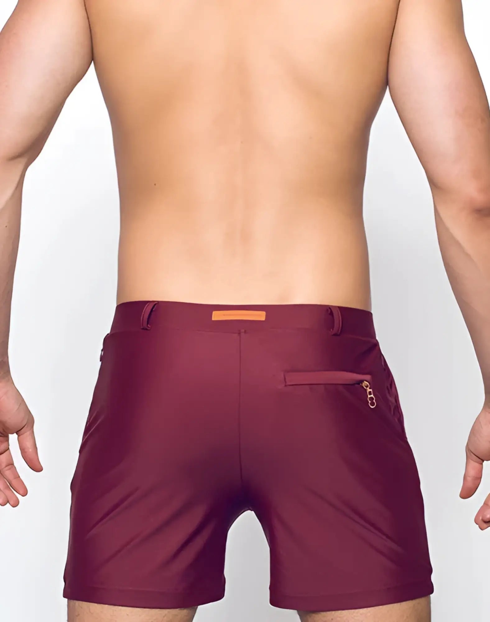 Maroon bondi short swim trunks with subtle textured finish and orange rectangular brand tag at the waistband