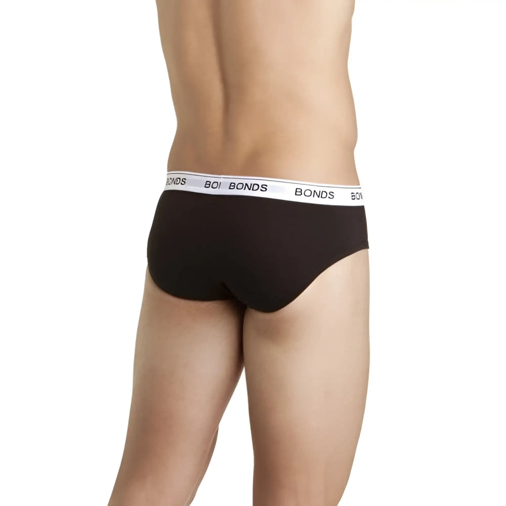Bonds guy front brief underwear in black with white elastic waistband featuring repeated brand name in size l