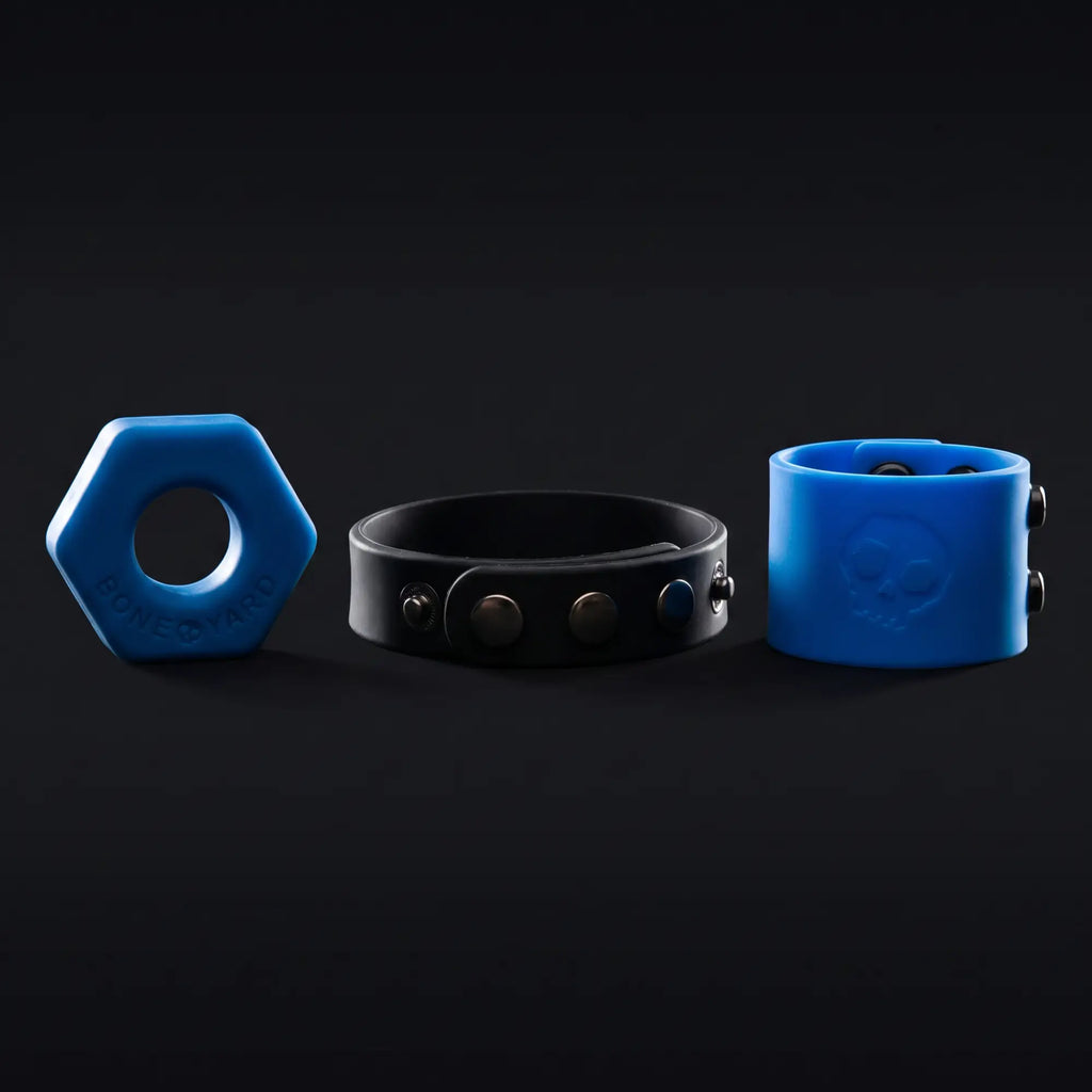 Boneyard Toys products — blue hex cock ring, cock strap and ball strap rim-lit on dark background