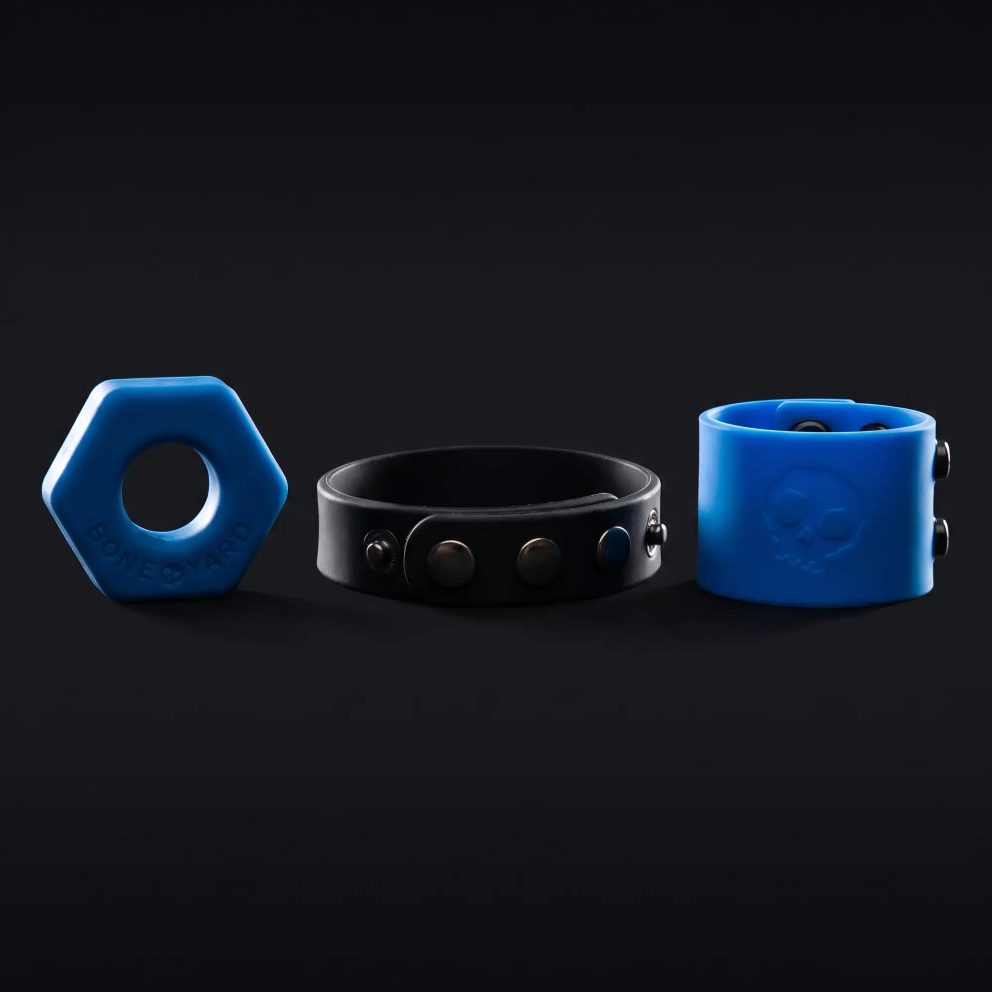 Boneyard Toys products — blue hex cock ring, cock strap and ball strap rim-lit on dark background