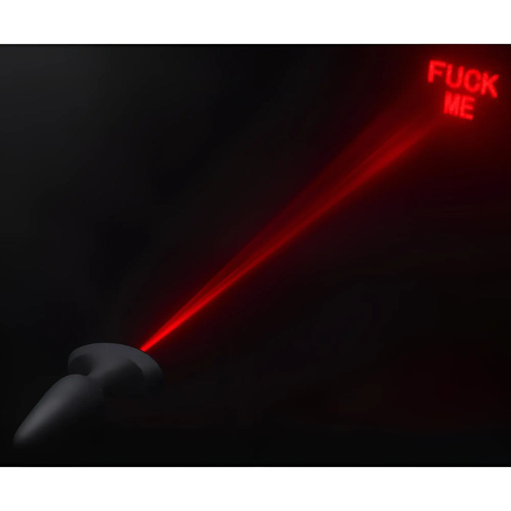 Black Booty Sparks silicone anal plug projecting a red laser beam that reads "FUCK ME" against a dark background.