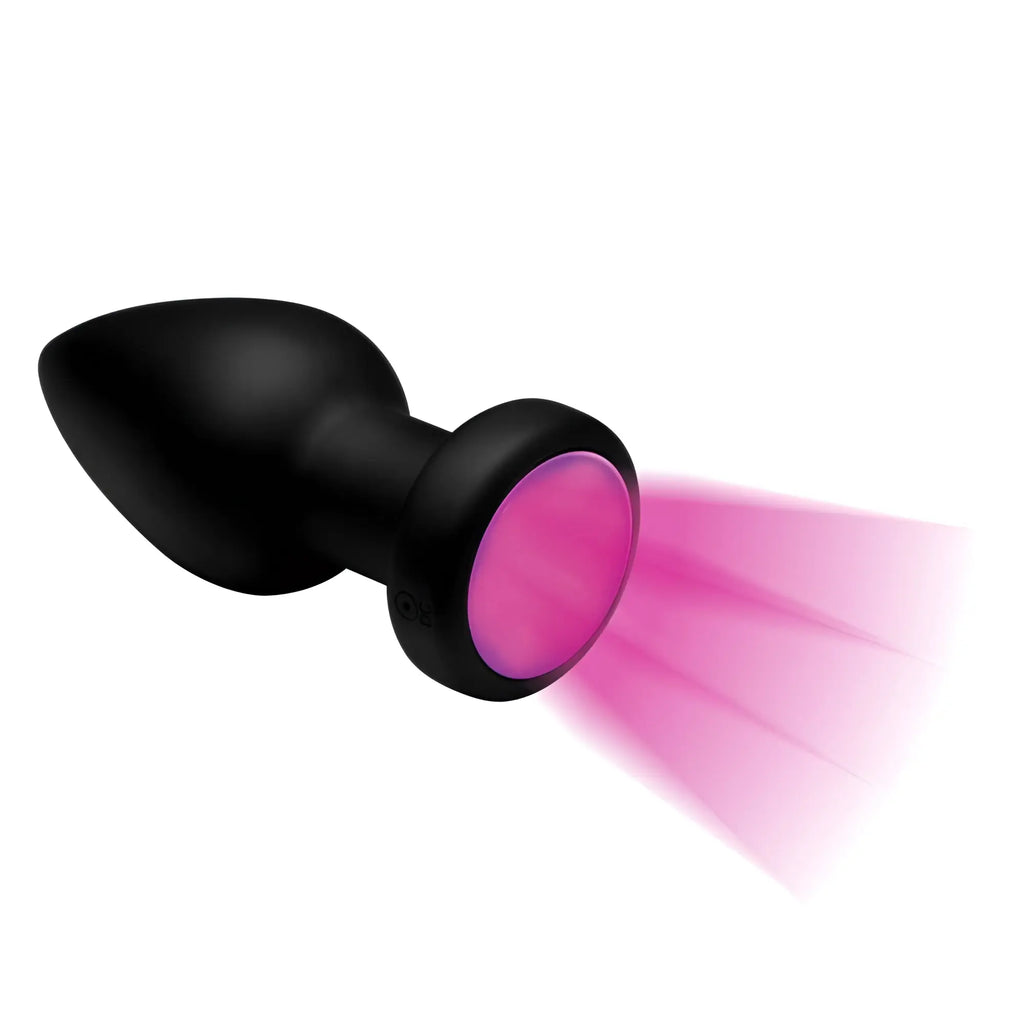 Booty Sparks 7X: Black silicone plug with a base that glows with bright pink light against a white background.