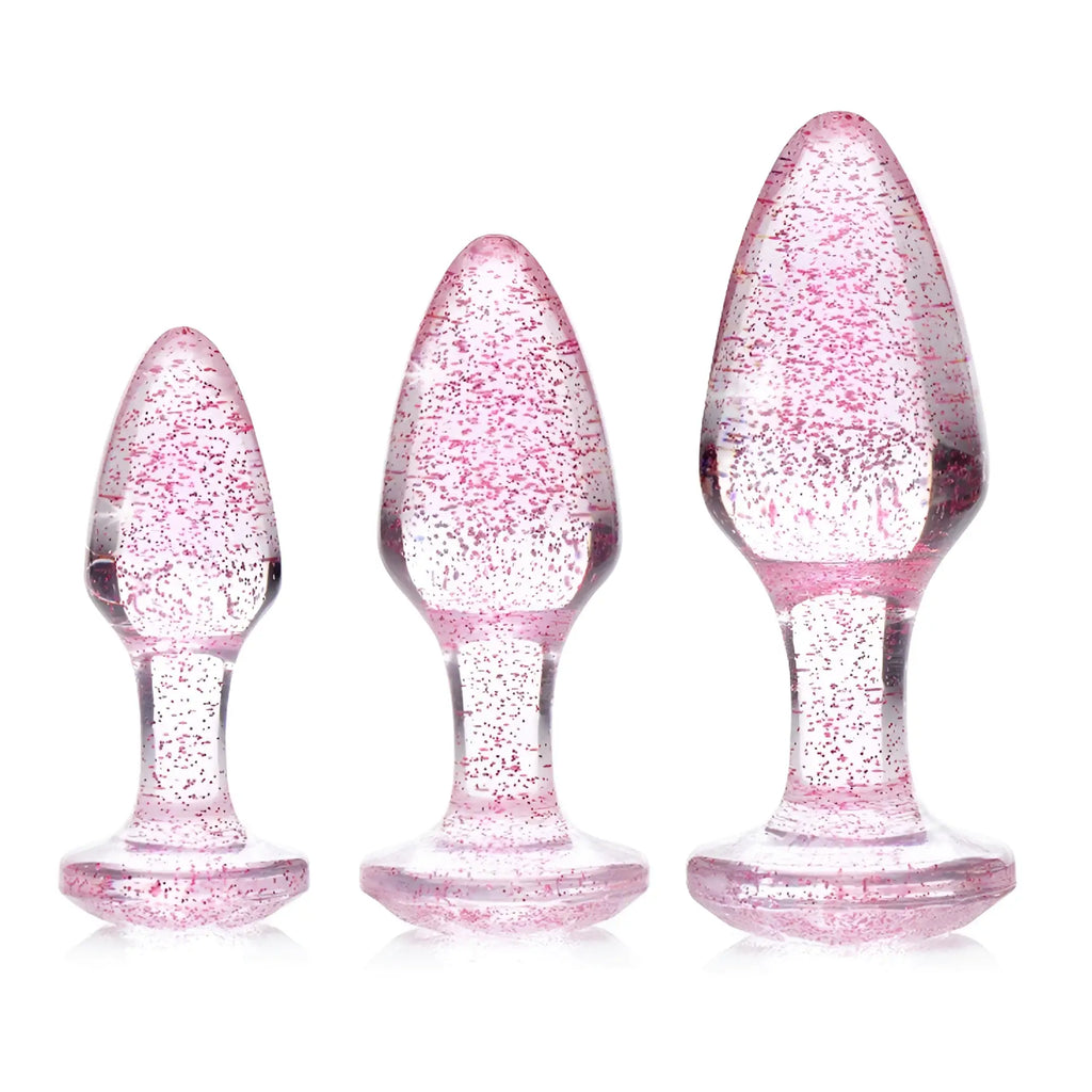 Booty Sparks Glitter Gem Anal Plug set: three clear, teardrop-shaped glass plugs with embedded pink glitter.
