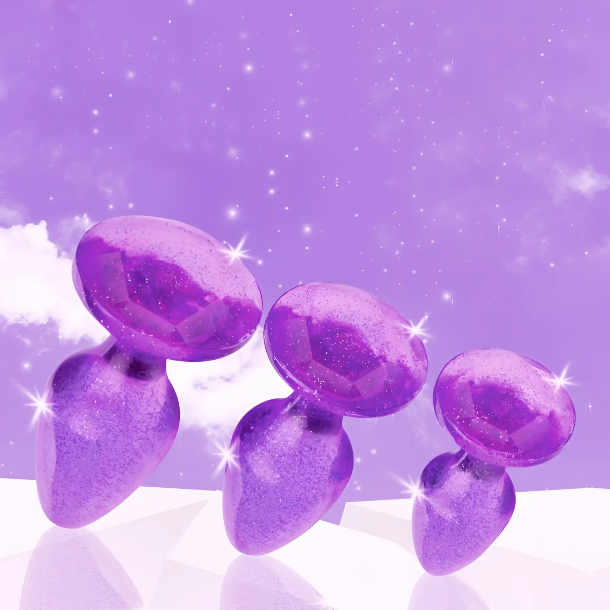Booty Sparks glitter gem anal plug set: three purple, sparkling, diamond-topped plugs in descending sizes.