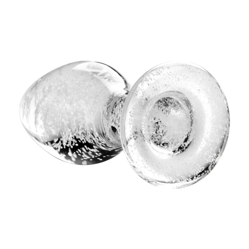 Booty Sparks glow-in-the-dark glass anal plug featuring a clear, bubble-filled textured design on a white background.