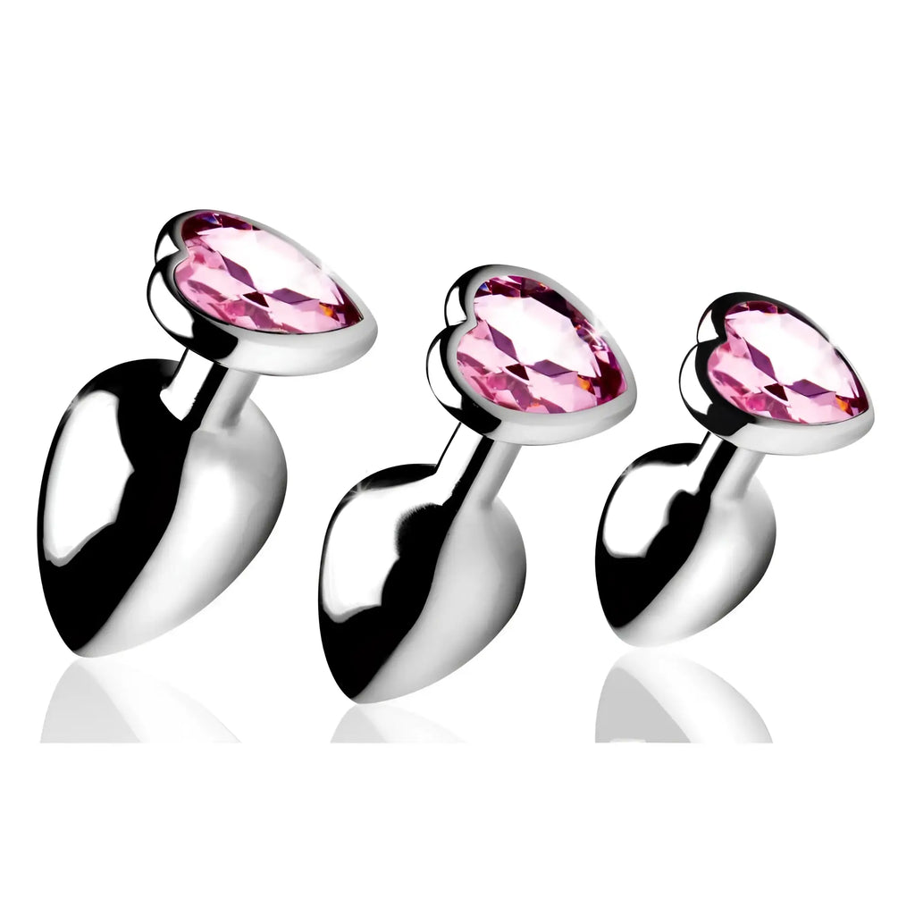Booty Sparks Pink Heart Anal Plug set: three silver metal plugs with faceted, heart-shaped pink gem bases.