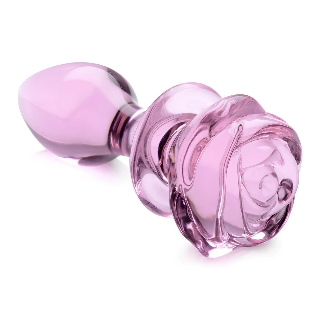 Booty Sparks pink glass anal plug with a detailed, rose-shaped base, isolated on a white background.