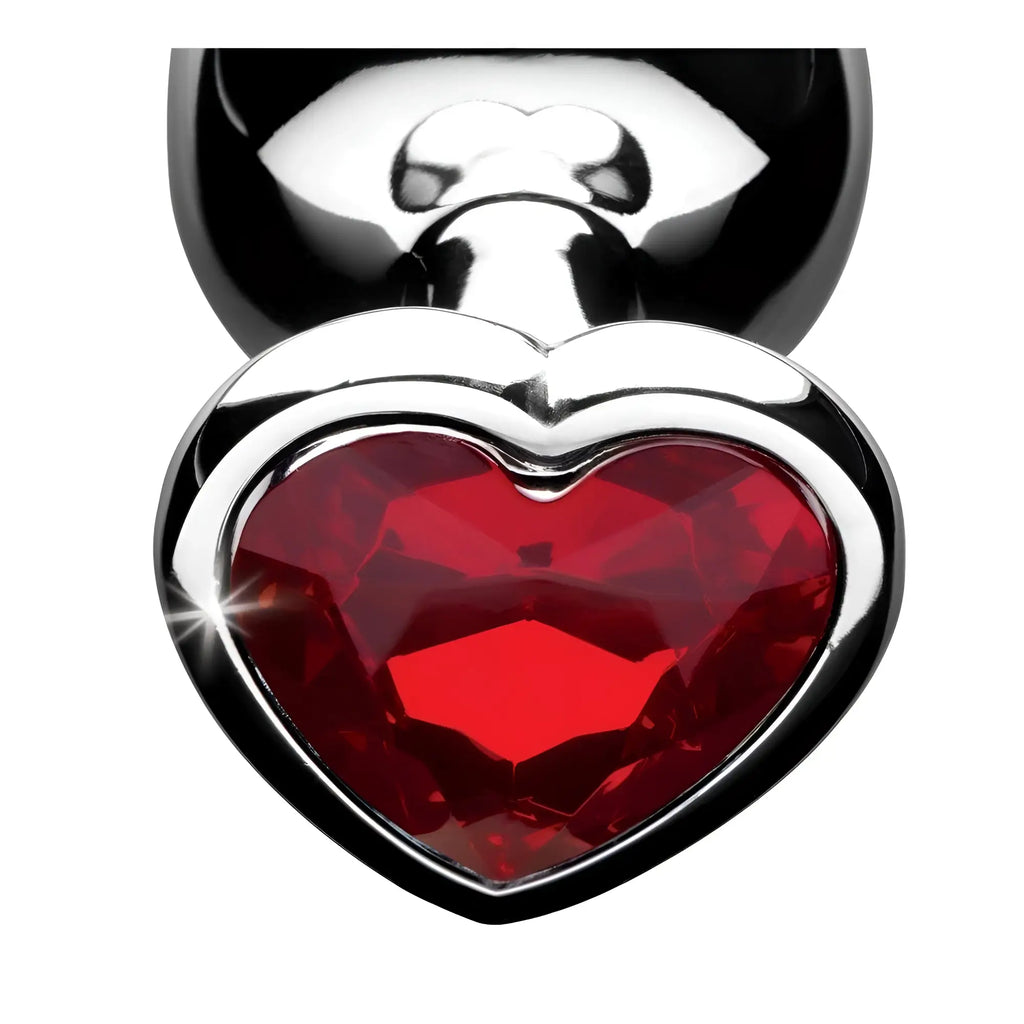 Booty Sparks Red Heart Gem Anal Plug: A shiny silver base featuring a large, faceted, red heart-shaped gemstone.
