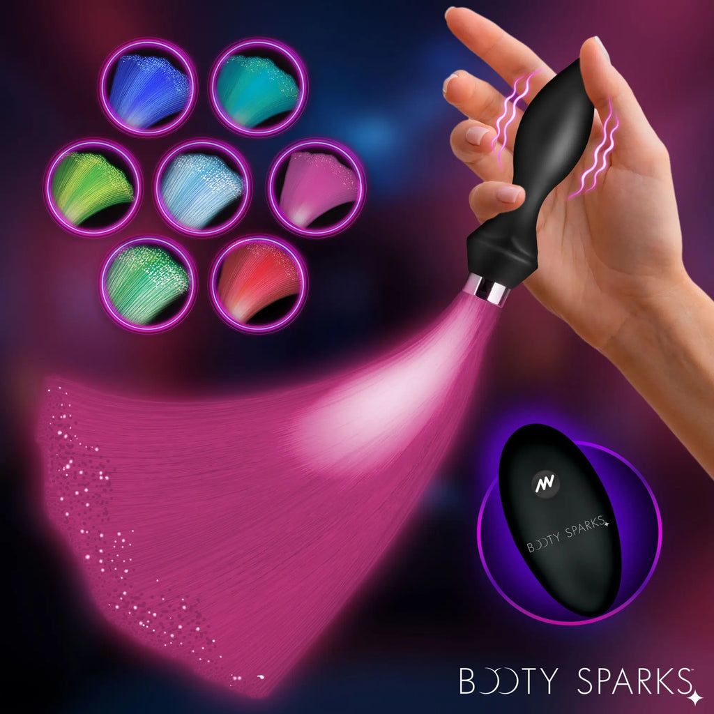 Booty Sparks vibrating silicone butt plug with glowing fiber optic tail in pink, showing multiple color options.