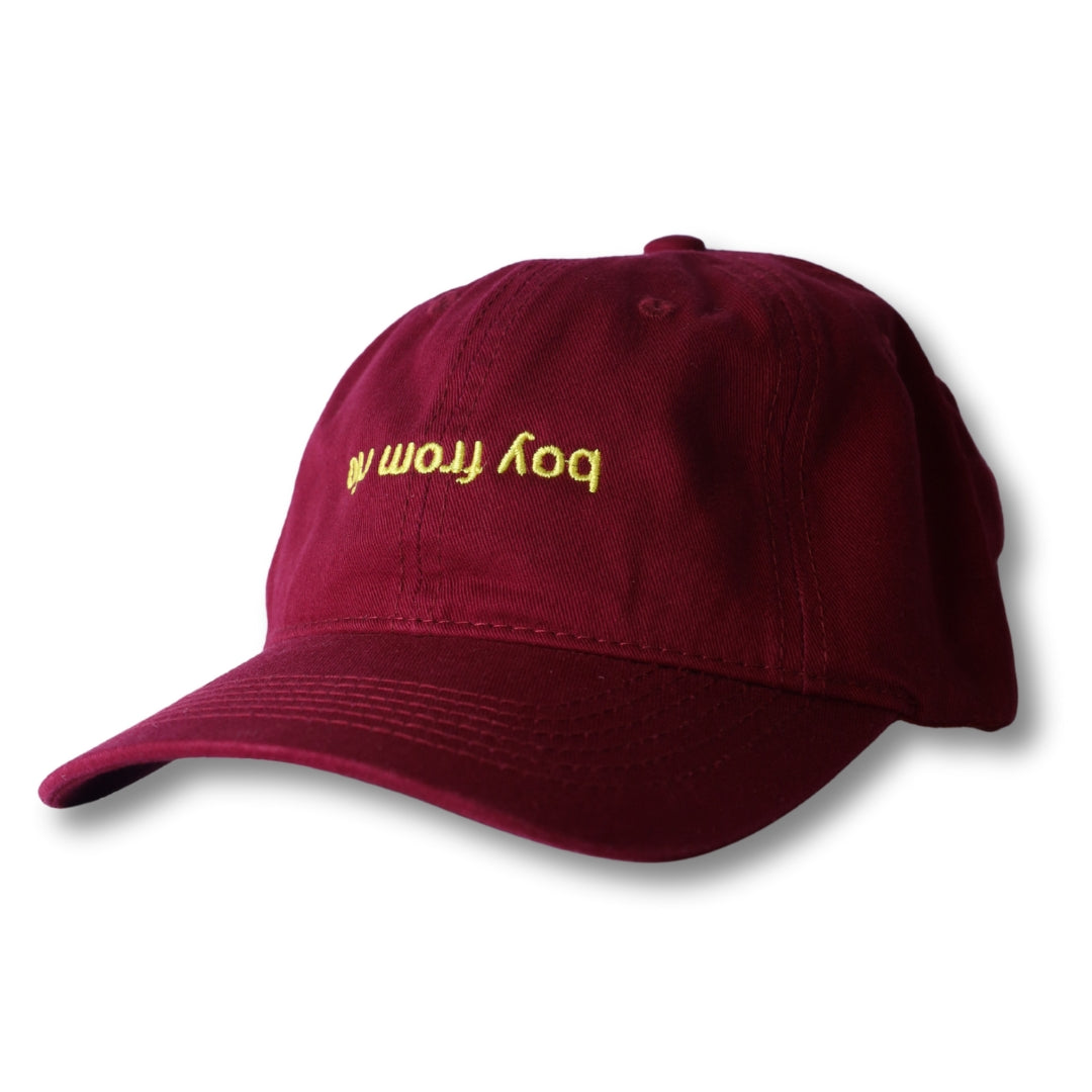 Maroon dad hat with gold embroidered boy from text on front from boy from rio flip collection