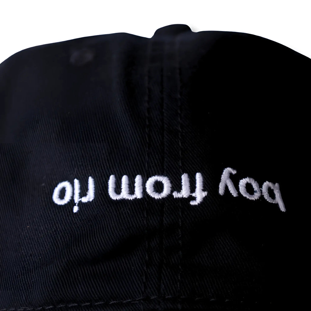 Black dad hat with white embroidered text boy from oil named boy from rio flip in cotton material
