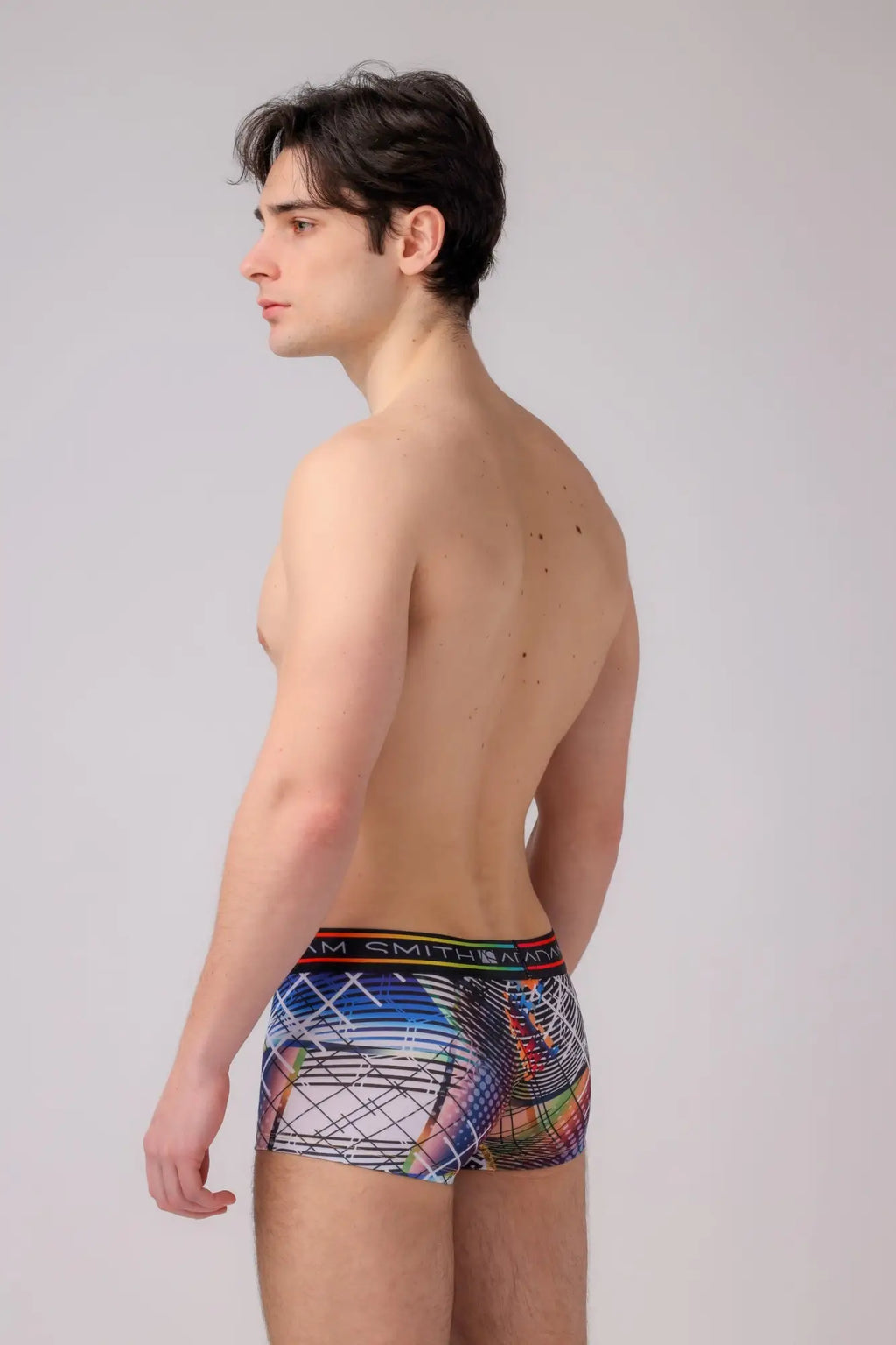 Multicolored abstract patterned men’s boyshort briefs with black elastic waistband featuring the m logo