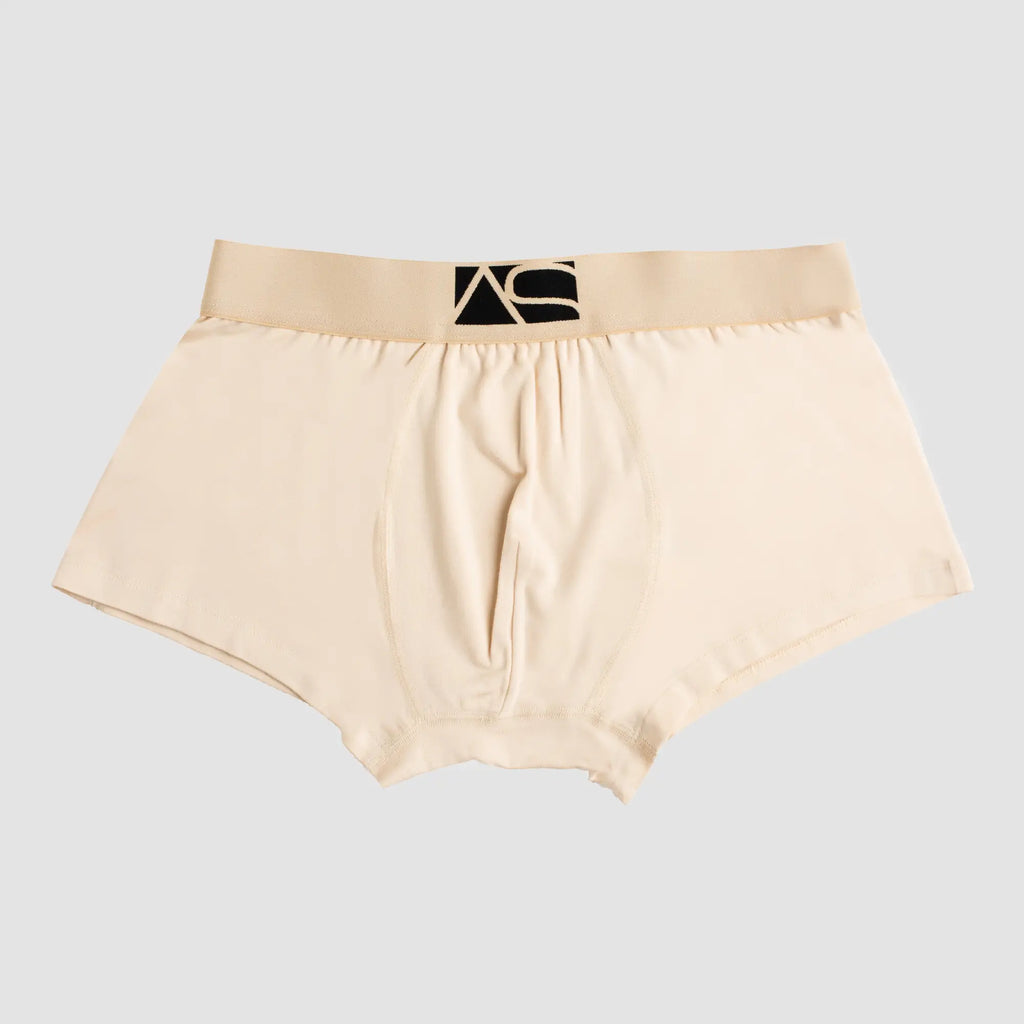 Beige men’s boyshorts briefs with a black logo waistband designed for comfortable everyday wear