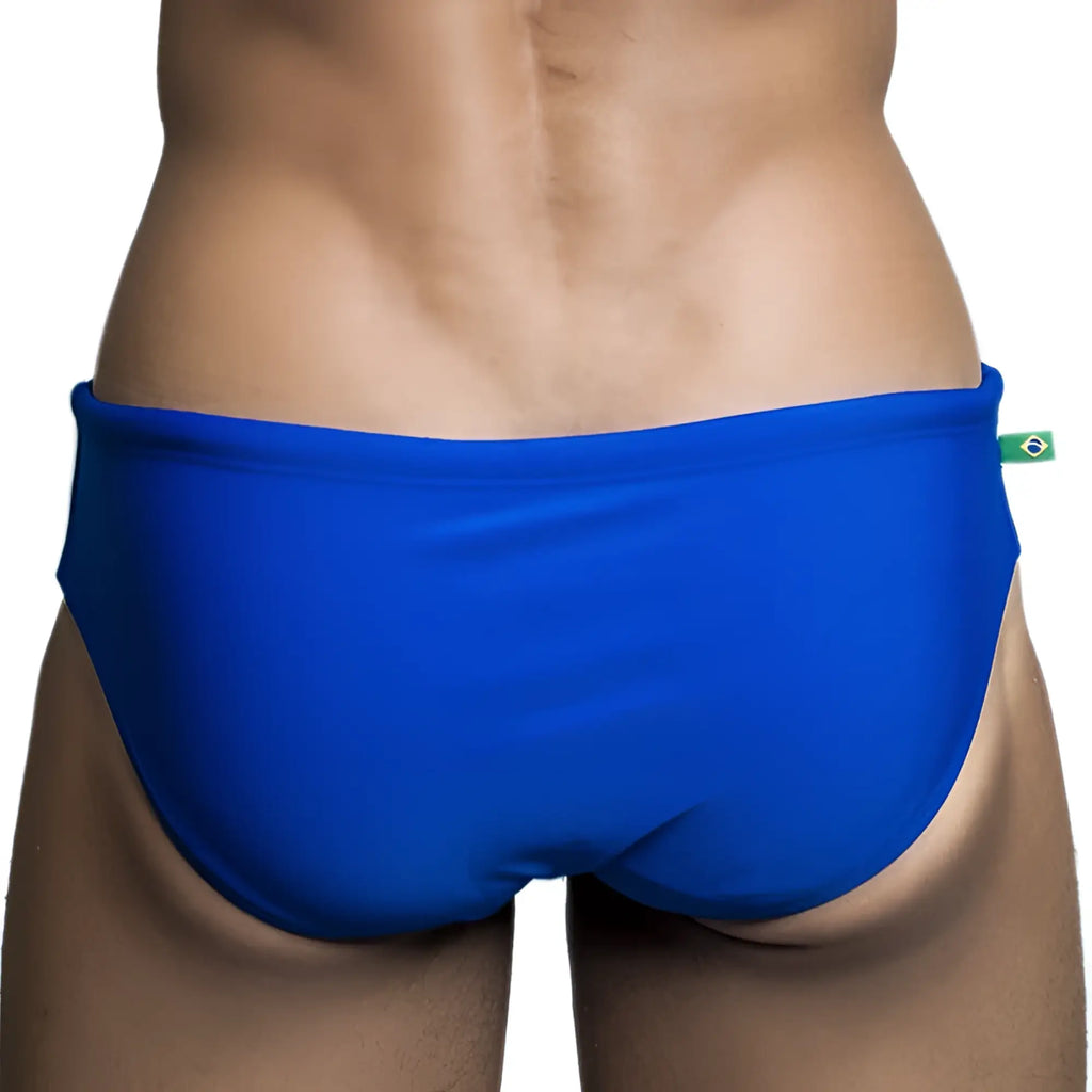Brief cut solids sunga male bathing suit in bright blue with a green and yellow brazilian flag tag on the waistband