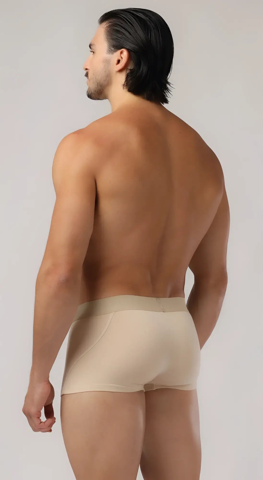 Beige brief trunks made of smooth form-fitting fabric with a subtle waistband for comfortable athletic wear